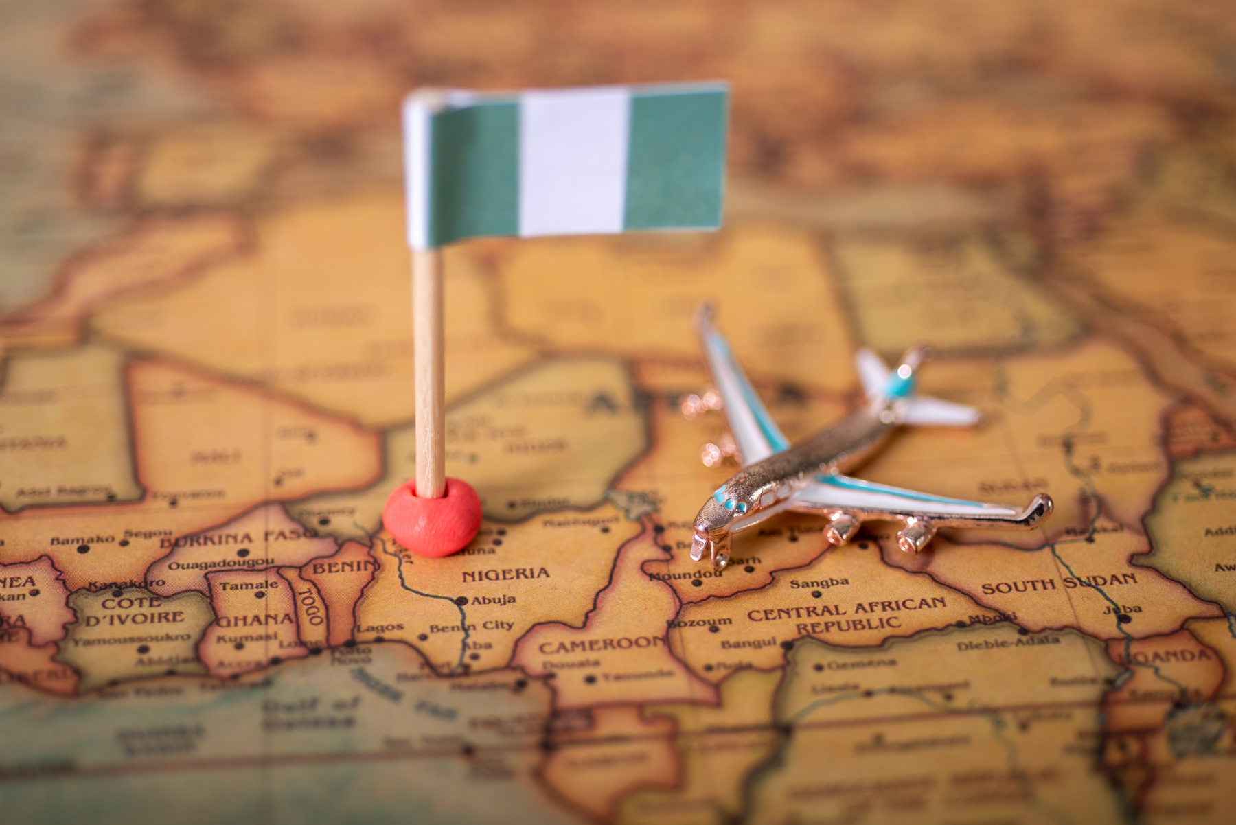 The flag of Nigeria and the airplane on the world map.