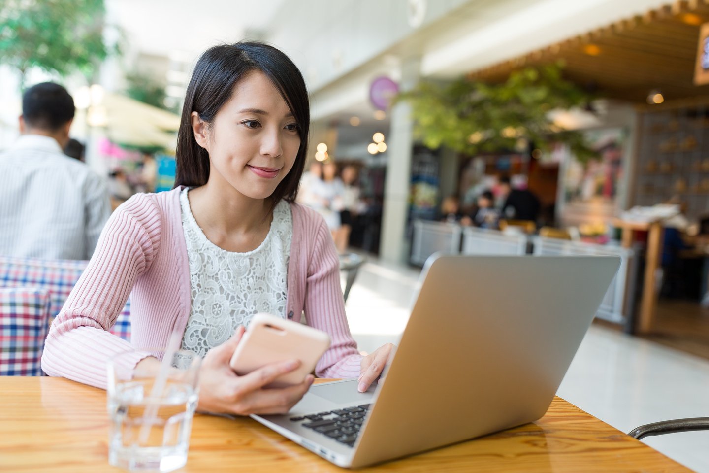 Woman Working on Laptop Computer and Cellphone